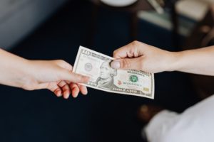 women-exchanging-ten-dollar-bill
