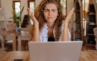 frustrated young woman working on laptop at home